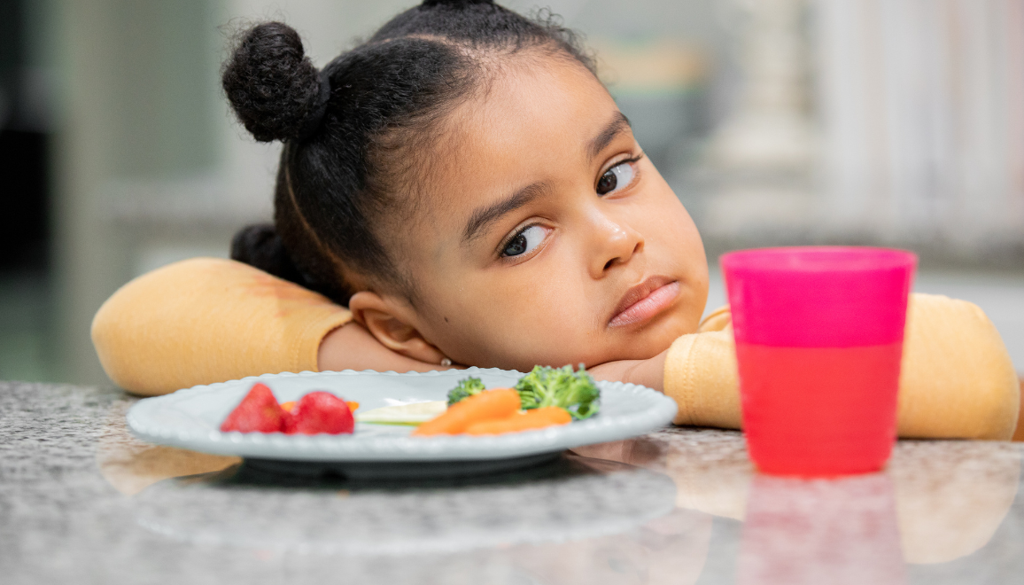 girl with food in front of her looking upset